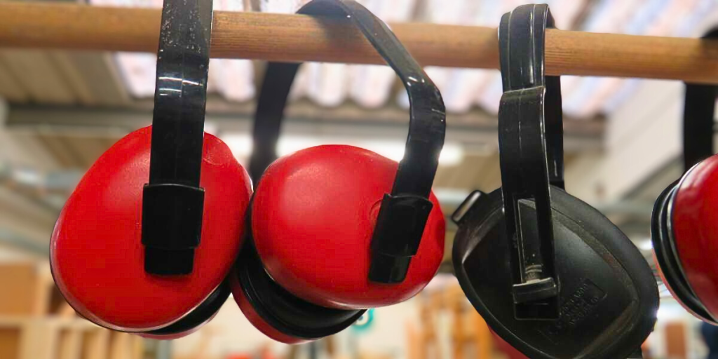 Black and red ear defenders hanging on a poll